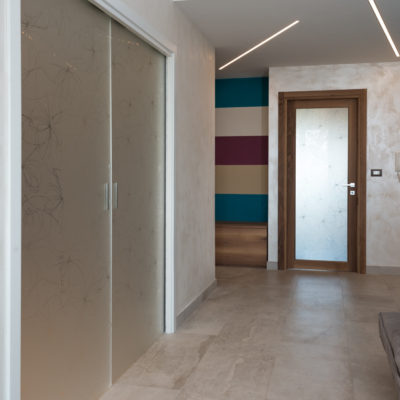 Porta scorrevole interno muro a 2 battenti in vetro temperato con rifiniture in legno laccato - Porta in noce nazionale con vetro smerigliato