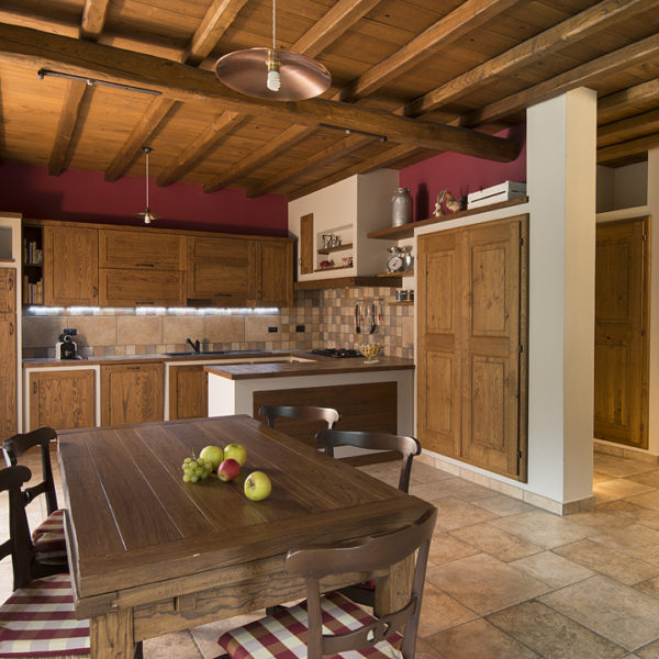 Cucina su misura in finta muratura castagno spazzolato, tavolo in castagno con prolunghe a scatto. Soffitto e porte in castagno