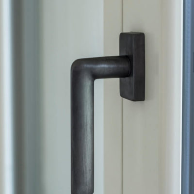 Dettaglio maniglia Ecolinea su anta finestrain legno Hemlock laccato bianco + alluminio per la parte esterna