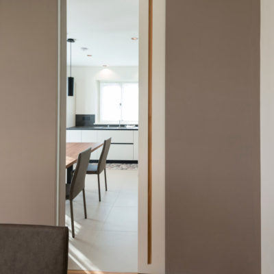 Porta scorrevoli intramuro a tutta altezza , tinta muro con inserto in rovere naturale (Arch. Paola Mazzaglia)