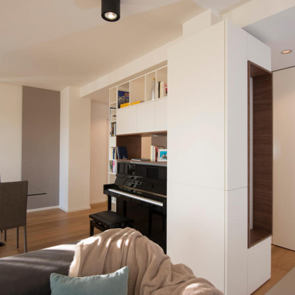 mobile laccato bianco e noce canaletto - Porte scorrevoli a tutta altezza tinta muro con inserto in rovere naturale (Arch. Paola Mazzaglia)