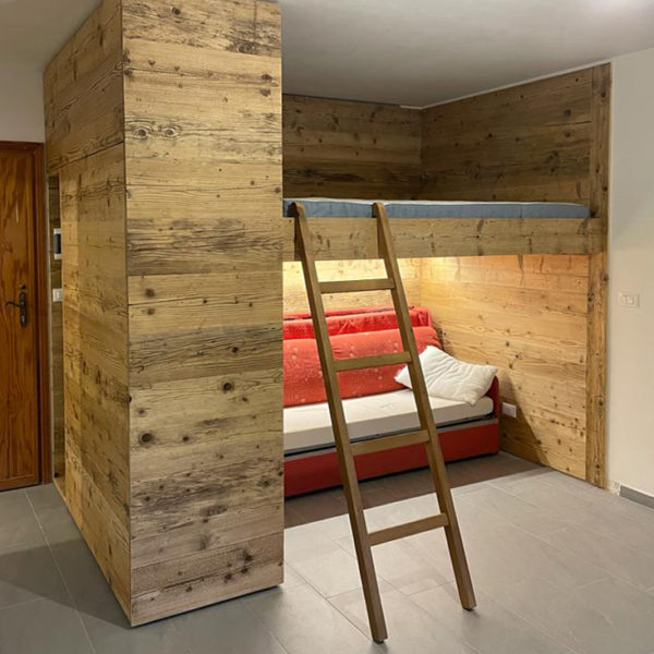 Area attrezzata con letto e divano letto in abete vecchio